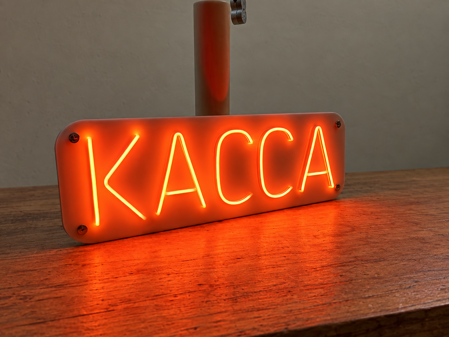 Неоновая надпись «Касса» с оранжевым свечением на стойке